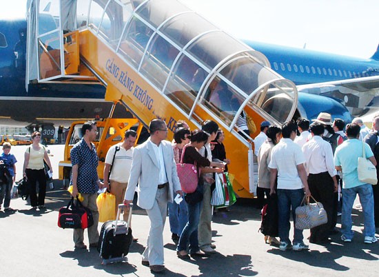 Passengers board a plane of the national flag carrier Vietnam Airlines (Photo: SGGP)